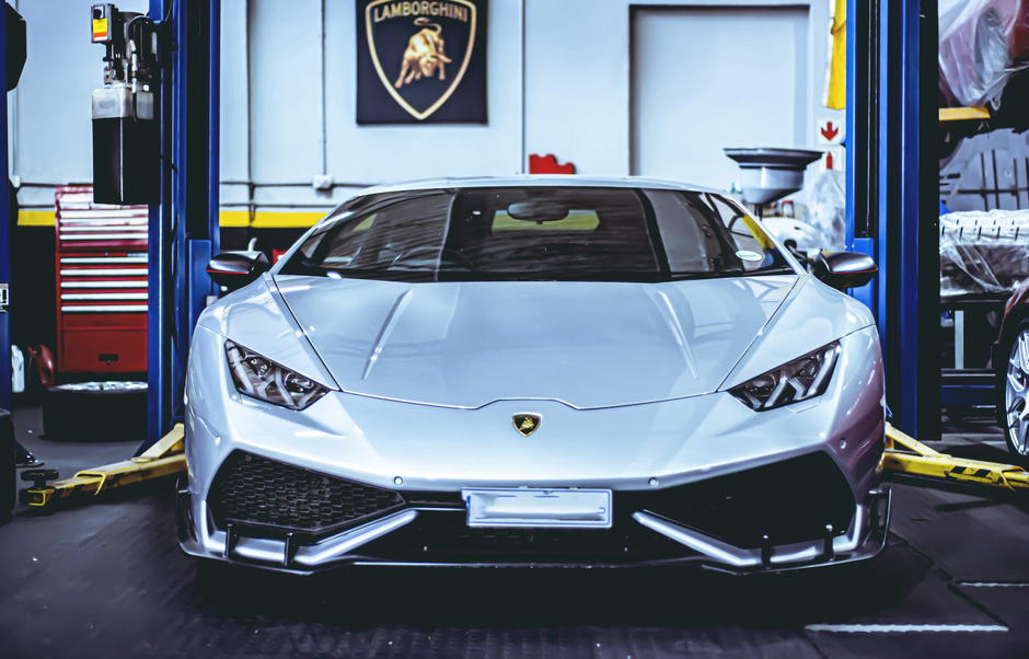 Front view of a Lamborghini Huracan in an automotive workshop, highlighting sleek design.